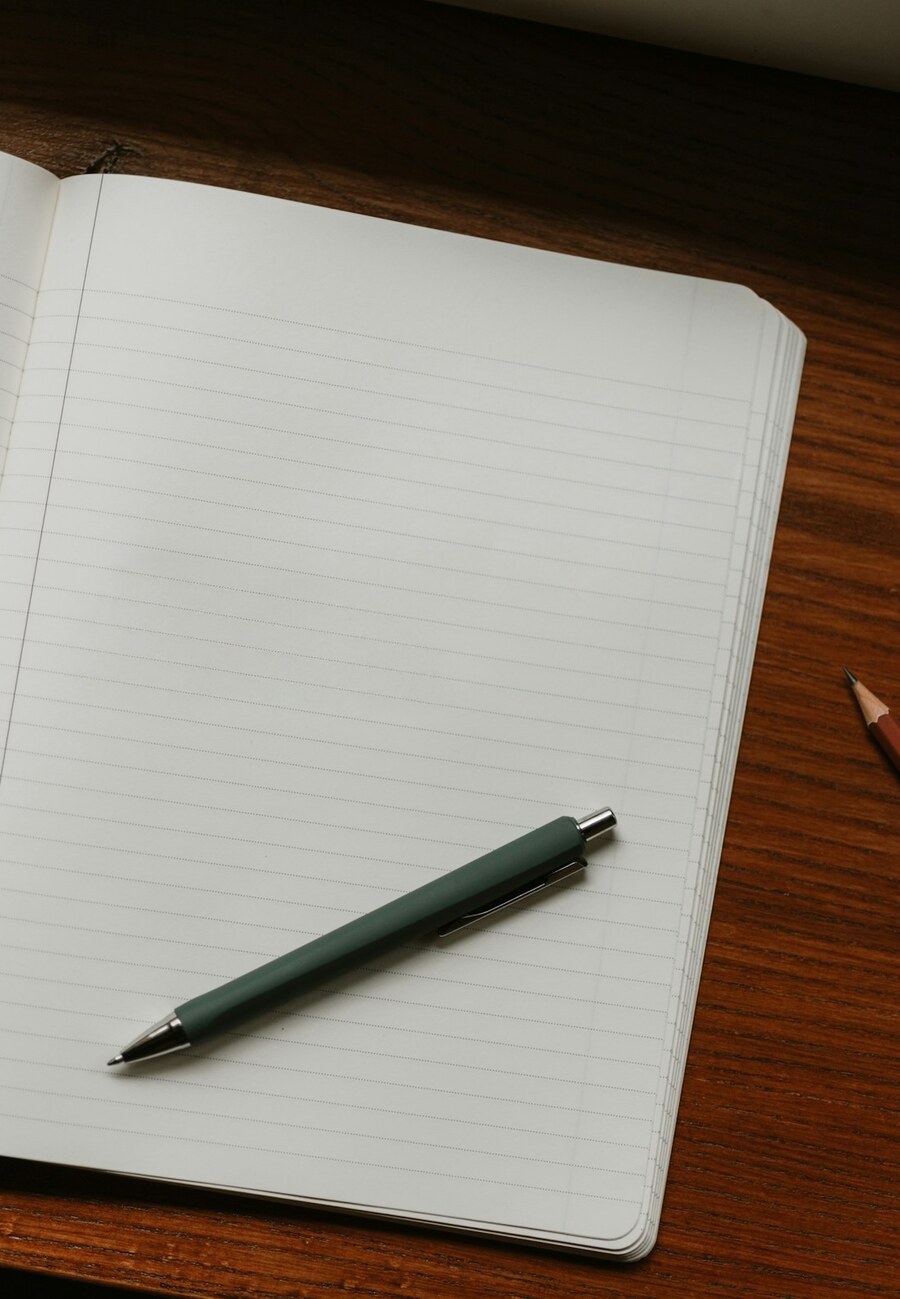 An open notebook and pen on a warm wooden desk — calm, focused learning